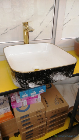 petit-lavabo-noir-avec-design-et-un-robinet-mitigeur-dore-big-0